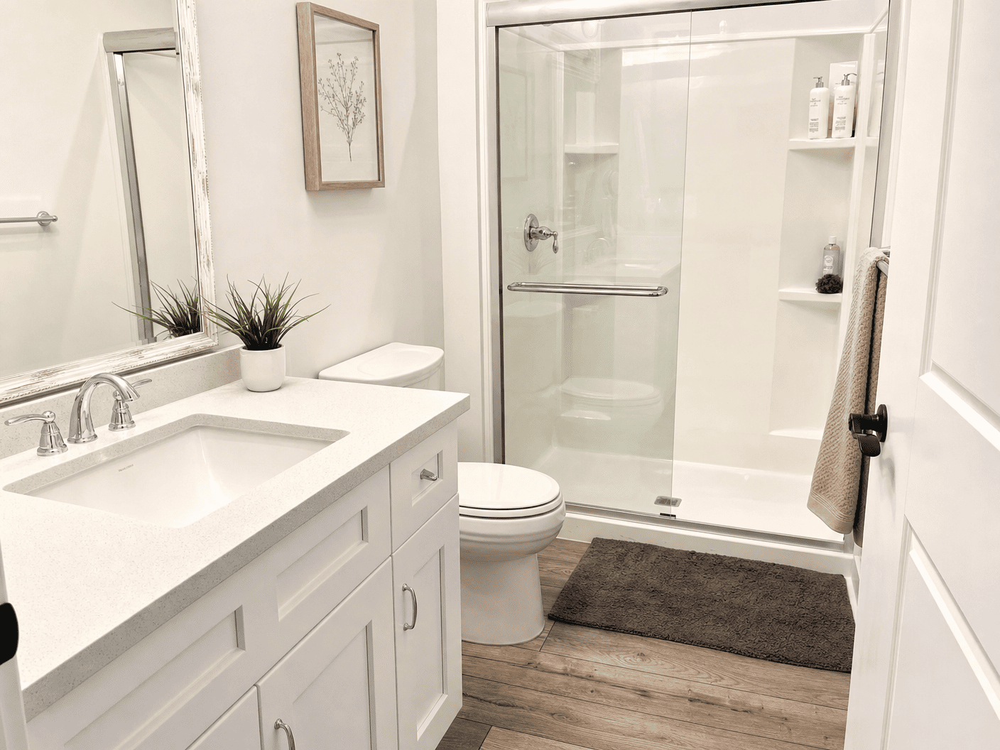 Bright bathroom with clean glass shower and white vanity