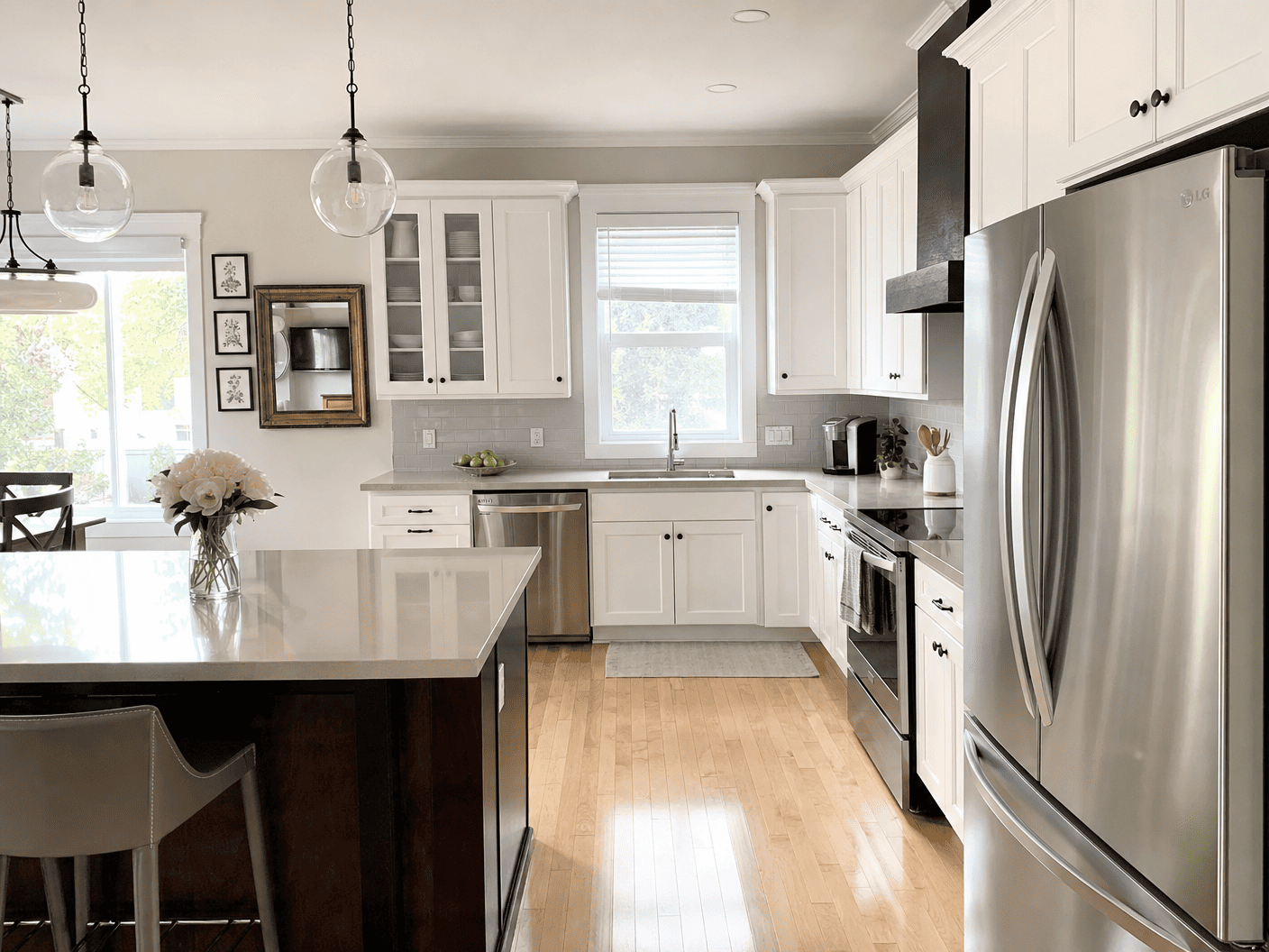 Bright white kitchen with polished counters and stainless steel appliances