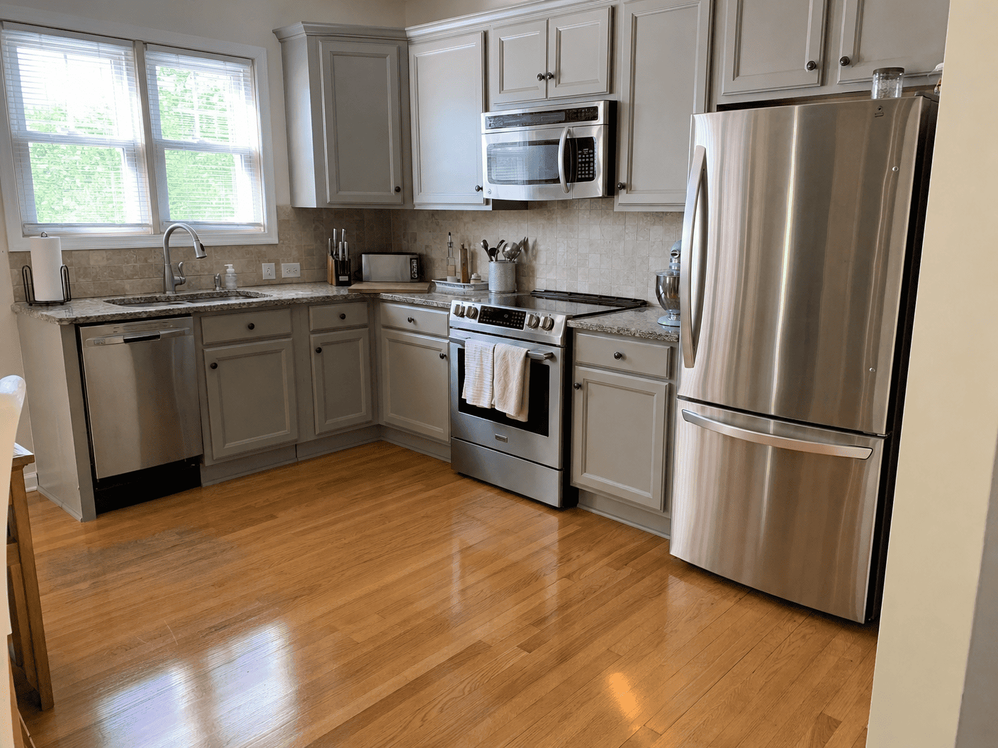 Polished kitchen with gray cabinets and hardwood floor